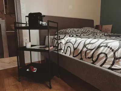 a bedroom with a bed with a black and white comforter at Have a Rest Netflix, Nespresso in Athens