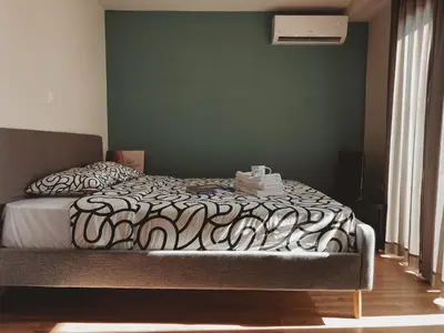 a bedroom with a bed with a black and white comforter at Have a Rest Netflix, Nespresso in Athens