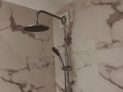 a shower in a bathroom with white marble walls at Have a Rest Netflix, Nespresso in Athens