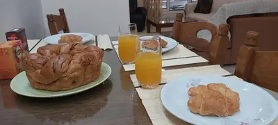a table with plates of food and two glasses of orange juice at Styl Apartment in Athens