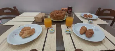 a table with plates of food and glasses of orange juice at Styl Apartment in Athens