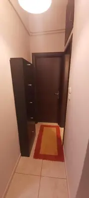 a hallway with a black door and a red rug at Styl Apartment in Athens