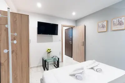 a bedroom with a bed and a tv on the wall at AIOLOS centre plateia nea smyrni in Athens