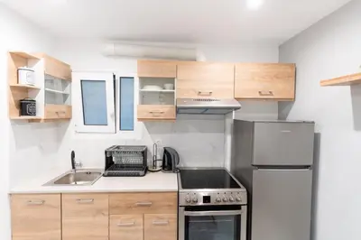 a small kitchen with a sink and a refrigerator at AIOLOS centre plateia nea smyrni in Athens