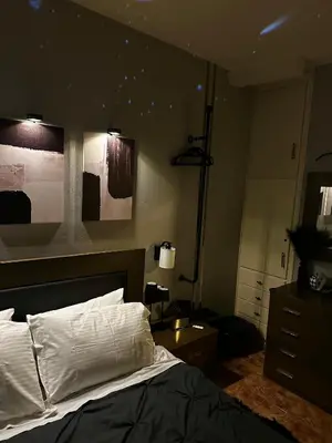 a bedroom with a bed with white sheets and a dresser at luxury house airport in Koropíon