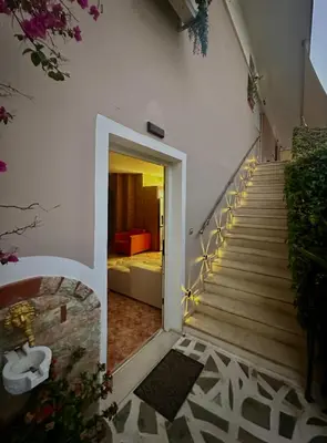 a stairway leading to a room with a bed at luxury house airport in Koropíon