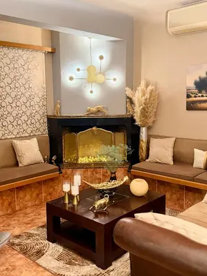 a living room with a couch and a fireplace at luxury house airport in Koropíon
