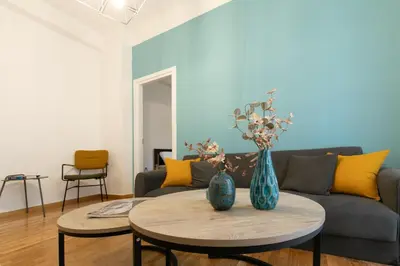 a living room with a couch and two vases on a table at Koukaki Gem Chic Apt near Acropolis in Athens