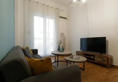a living room with a couch and a flat screen tv at Koukaki Gem Chic Apt near Acropolis in Athens