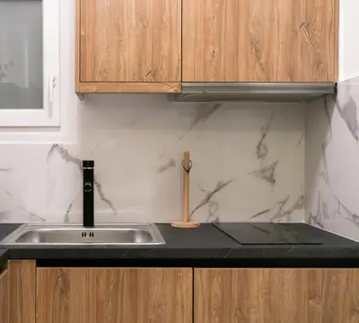 a kitchen with a sink and wooden cabinets at Koukaki Gem Chic Apt near Acropolis in Athens
