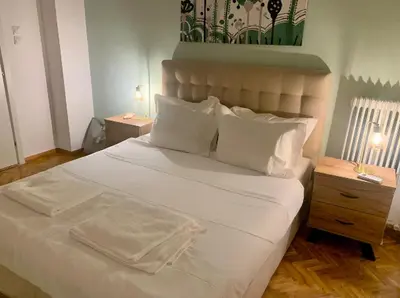 a bedroom with a large bed with white sheets and pillows at Koukaki Gem Chic Apt near Acropolis in Athens