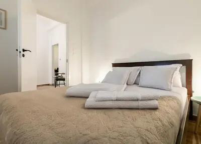 a white bedroom with a large bed with white pillows at Koukaki Gem Chic Apt near Acropolis in Athens
