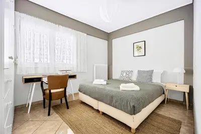 a bedroom with a bed and a desk and a desk at Bright & Cosy in Athens! in Athens