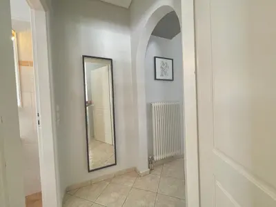a hallway with a mirror and a tile floor at Bright & Cosy in Athens! in Athens