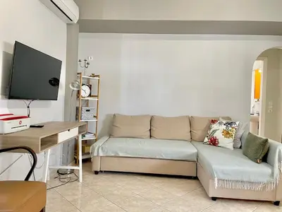 a living room with a couch and a desk at Bright & Cosy in Athens! in Athens