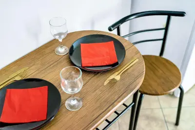 a wooden table with two plates and wine glasses at Bright & Cosy in Athens! in Athens