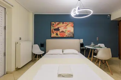 a bedroom with a white bed and a blue wall at Aiolos GLYFADA super lux apartment in Athens
