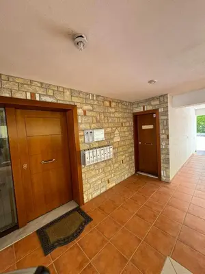 a lobby with two doors and a brick wall at Aiolos GLYFADA super lux apartment in Athens