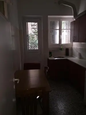a kitchen with a table and a sink and a window at Work, relax, enjoy - SHARED APARTMENT in Athens