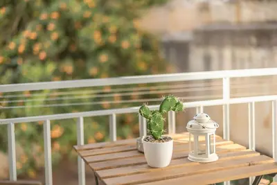 a wooden table with a potted plant on a balcony at Cozy home near Stavros Niarchos in Athens