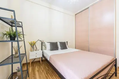 a bedroom with a bed and a shelf at Cozy home near Stavros Niarchos in Athens