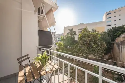 a balcony with a bench next to a building at Cozy home near Stavros Niarchos in Athens