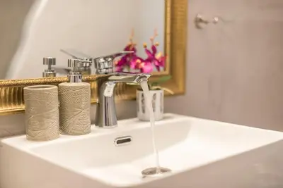a bathroom sink with a faucet and two rolls of paper towels at Cozy home near Stavros Niarchos in Athens