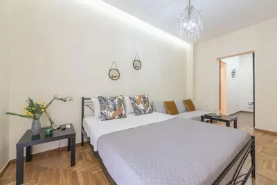 a white bedroom with a bed and a couch at Cozy home near Stavros Niarchos in Athens