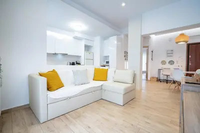 a living room with a white couch and yellow pillows at Athens central train station flat for 4 persons in Athens