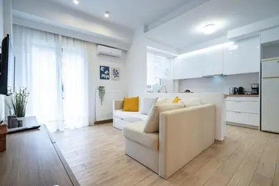 a living room with a couch and a kitchen at Athens central train station flat for 4 persons in Athens
