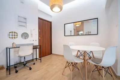 a dining room with white chairs and a table and a mirror at Athens central train station flat for 4 persons in Athens