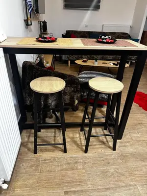 a table with two stools and a table with a cat under it at NEW COSY HOME KYPSELI ATHENS heart! in Athens