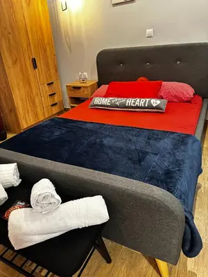 a bedroom with a bed with a blue and red blanket at NEW COSY HOME KYPSELI ATHENS heart! in Athens