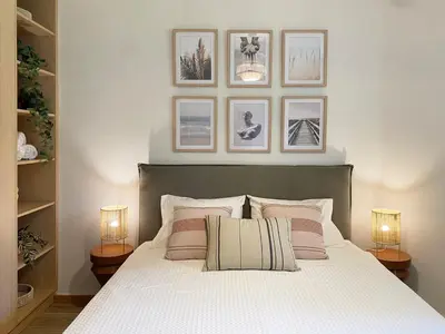 a bedroom with a bed with three pictures on the wall at Calm Cove One-Bedroom Home Glyfada in Athens