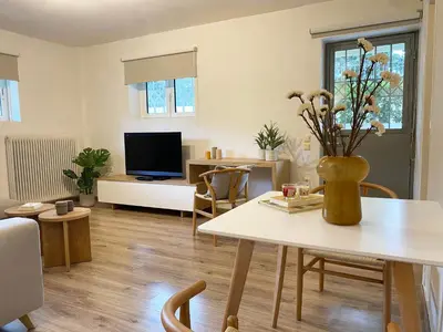 a living room with a table with a vase of flowers at Calm Cove One-Bedroom Home Glyfada in Athens