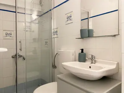 a bathroom with a sink and a toilet and a shower at Calm Cove One-Bedroom Home Glyfada in Athens