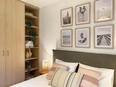 a bedroom with a bed and some pictures on the wall at Calm Cove One-Bedroom Home Glyfada in Athens