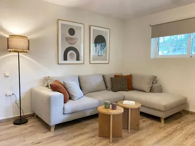 a living room with a couch and a table at Calm Cove One-Bedroom Home Glyfada in Athens