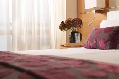 a bedroom with a bed with a pillow and a window at Divani Escape - Adults Only in Athens