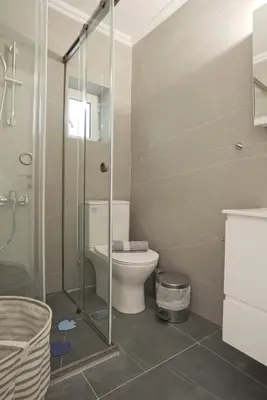a bathroom with a toilet and a glass shower at Porto 118 New Reno Piraeus St near Marina Zeas, AC in Piraeus