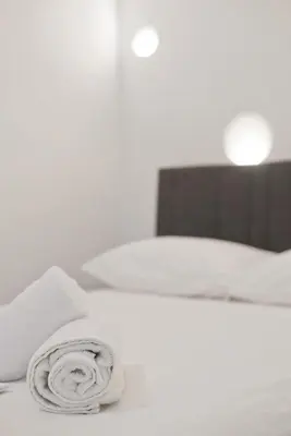 a white bed with a roll of towels on it at Porto 118 New Reno Piraeus St near Marina Zeas, AC in Piraeus