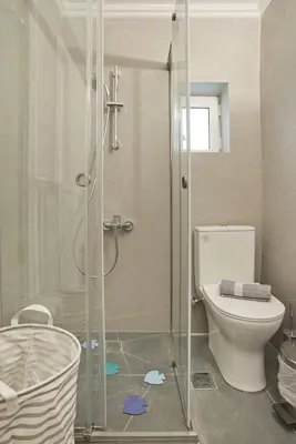 a bathroom with a toilet and a glass shower at Porto 118 New Reno Piraeus St near Marina Zeas, AC in Piraeus