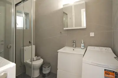 a bathroom with a toilet and a sink and a mirror at Porto 118 New Reno Piraeus St near Marina Zeas, AC in Piraeus