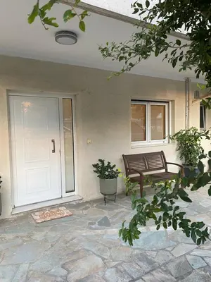 a porch with a bench and a white door at Cosy Lux Apartment in Athens