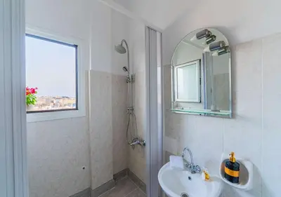 a white bathroom with a sink and a mirror at Amazing View Studio at Filopappou Hill in Koukaki! in Athens