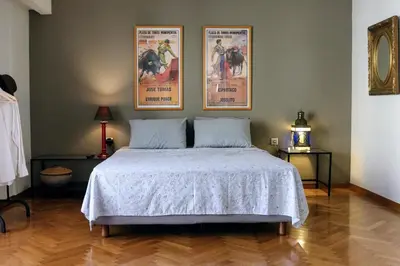 a bedroom with a bed with two posters on the wall at Central Apartment near Archeological Museum in Athens