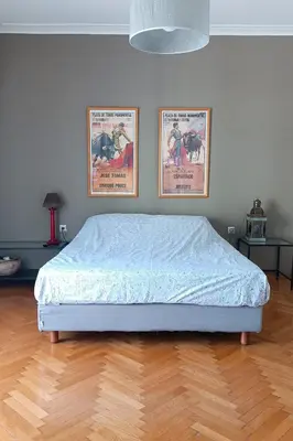 a bed in a bedroom with two posters on the wall at Central Apartment near Archeological Museum in Athens