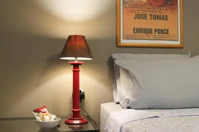 a red lamp on a table next to a bed at Central Apartment near Archeological Museum in Athens