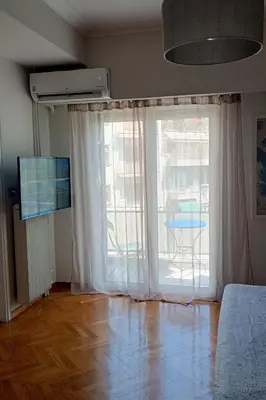 a living room with a large window and a table at Central Apartment near Archeological Museum in Athens