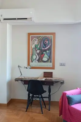 a desk in a room with a painting on the wall at Central Apartment near Archeological Museum in Athens